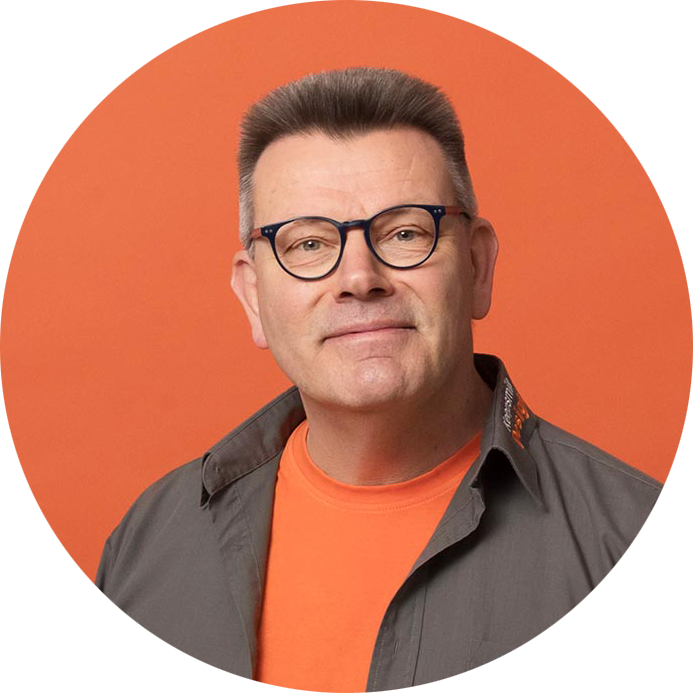 Ein Porträtbild von Uwe Wortmann, Inhaber der Webagentur Keepsmile Design, Castrop-Rauxel, vor einem orangefarbigen Hintergrund. Orange ist die Firmenfarbe