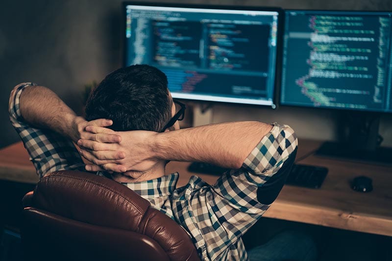 Ein Mann der entspannt vor einem Computer sitzt. Ein Beispielbild für den Managed Service von Keepsmile Design