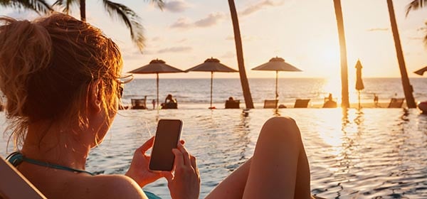 Eine Frau sitzt im Süden am Pool
