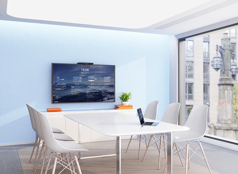 Konferenzraum mit Tisch und 6 weißen Stühlen und einem Display an der Wand. Auf dem Bildschirm ist das Startbild vom RoomCast zu sehen. Konferenzraum mit Tisch und 6 weißen Stühlen und einem Display an der Wand. Auf dem Bildschirm ist das Startbild vom RoomCast zu sehen.