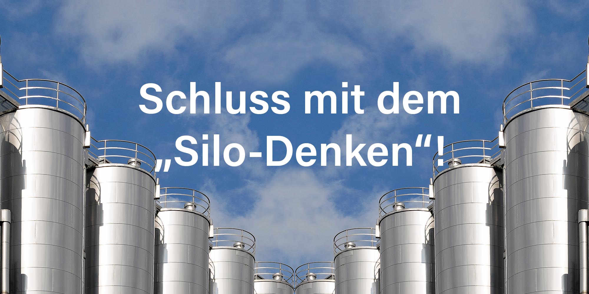 viele silberfarbige Metallsilos vor einem blauen Himmel mit einigen weißen Wolken mit dem Schriftzug: 