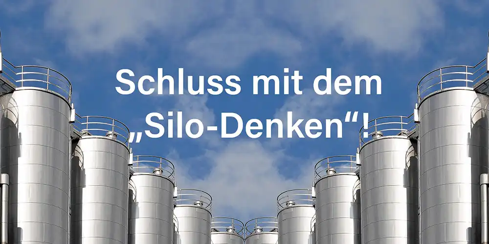 Einige Silotürme vor einen leicht bewölkten blauen Himmel. Im Himmel steht Schluss mit dem Silo-Denken Symbolfoto für HubSpot CRM